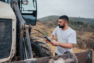 a man in a white shirt is working on a tractor