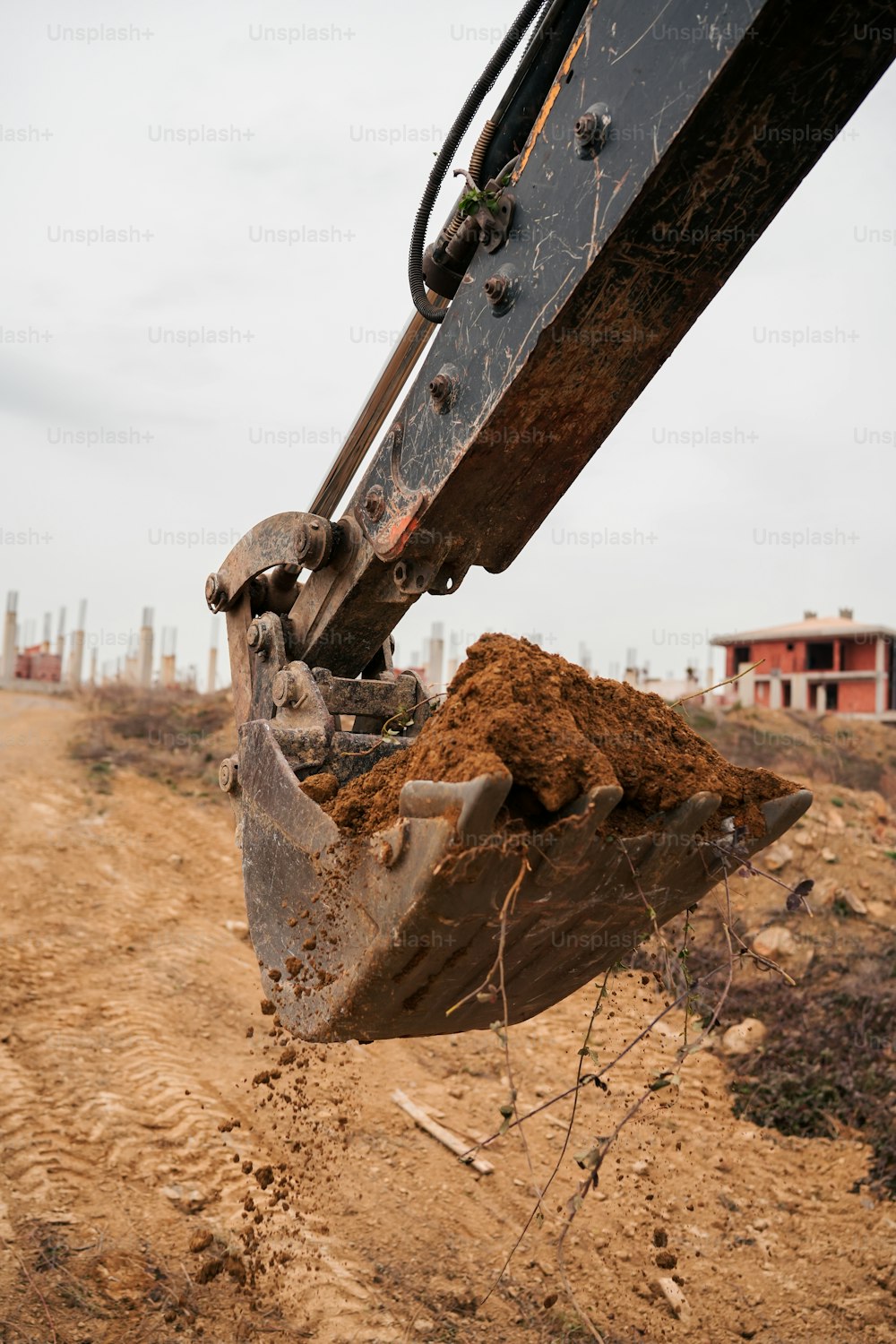 uma escavadeira cavando terra em uma estrada de terra