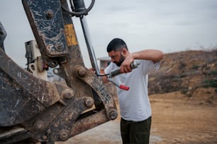 Ein Mann benutzt einen Bohrer, um eine Maschine zu reparieren