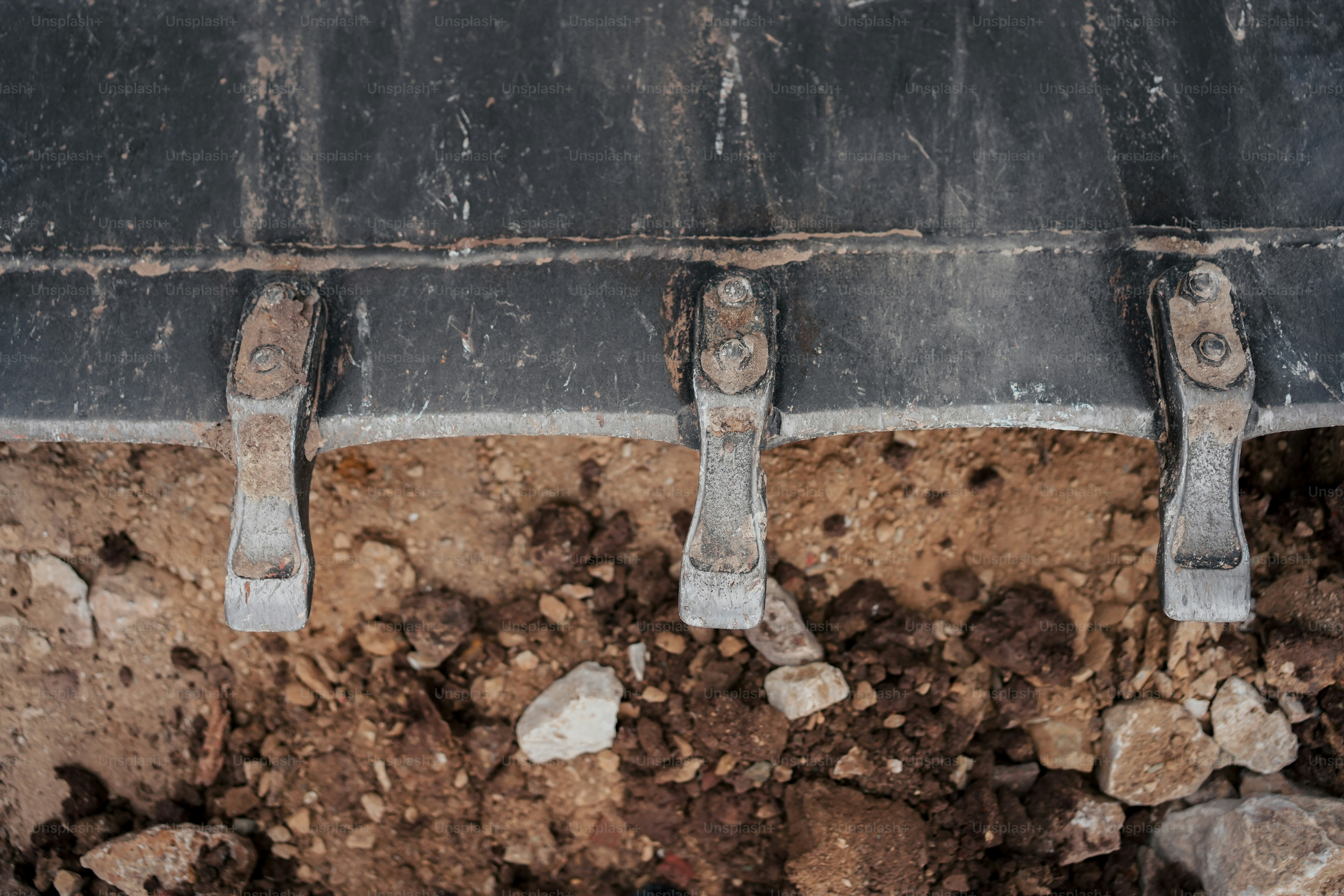 Un primer plano de un riel de metal en un suelo de tierra