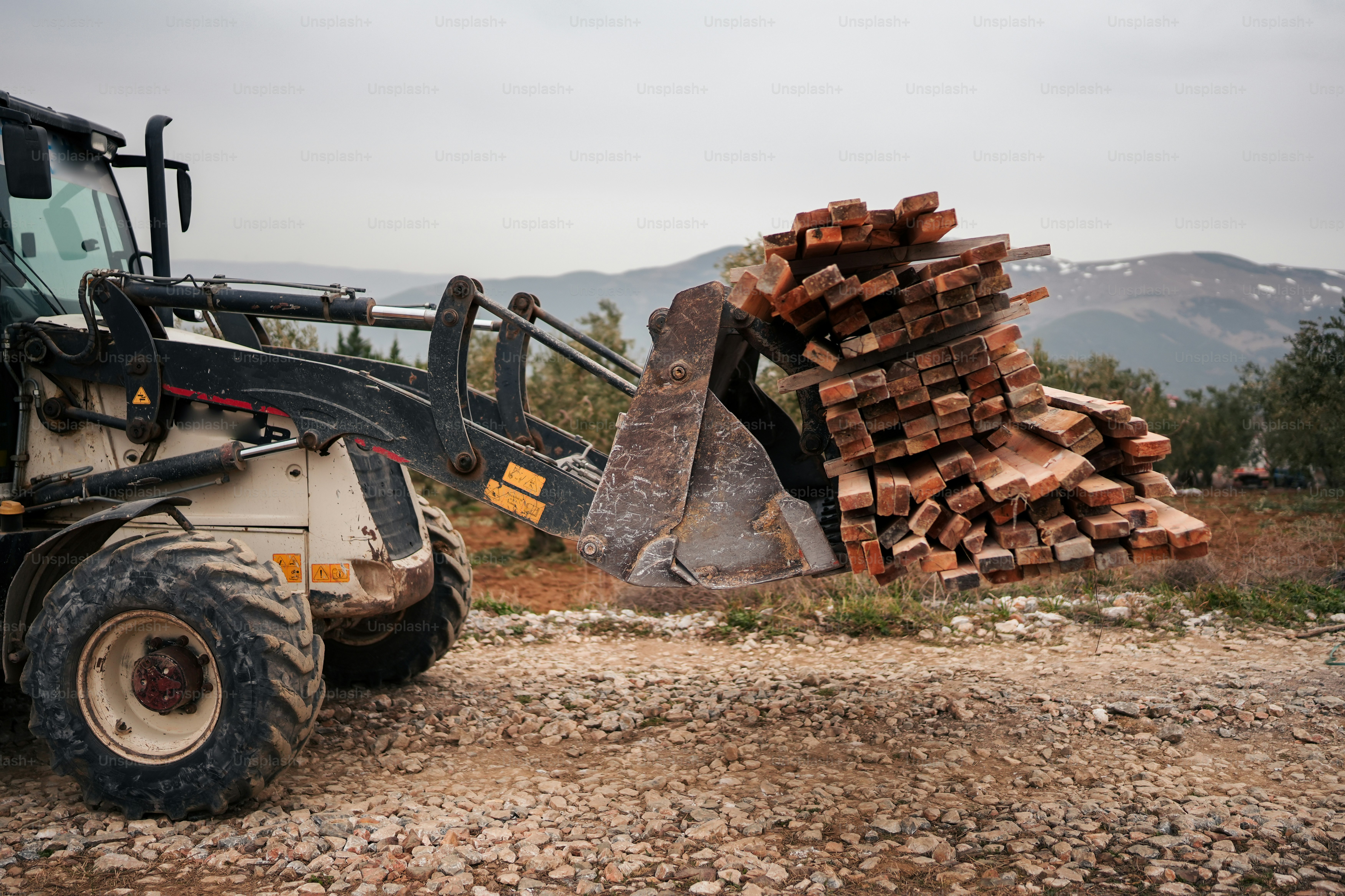 a large load of wood sitting on top of a pile of dirt