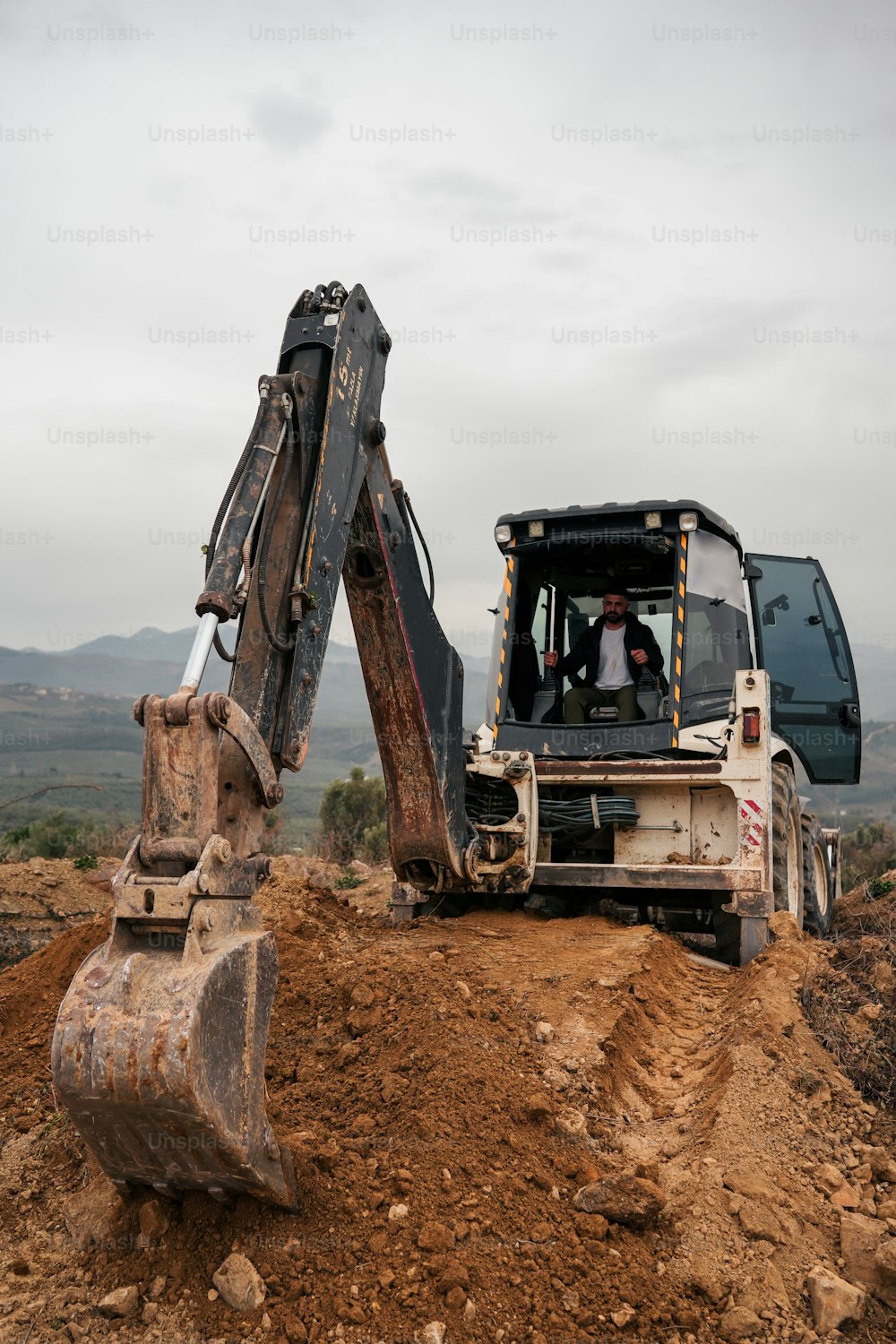an excavator and a bulldozer on a dirt hill