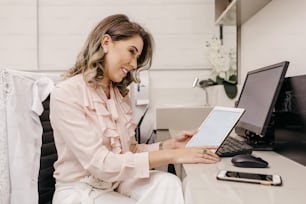 a woman sitting at a desk using a laptop computer