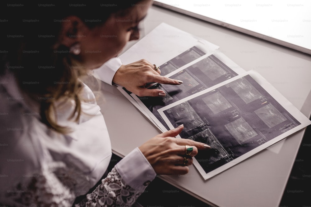 a woman sitting at a table holding a piece of paper