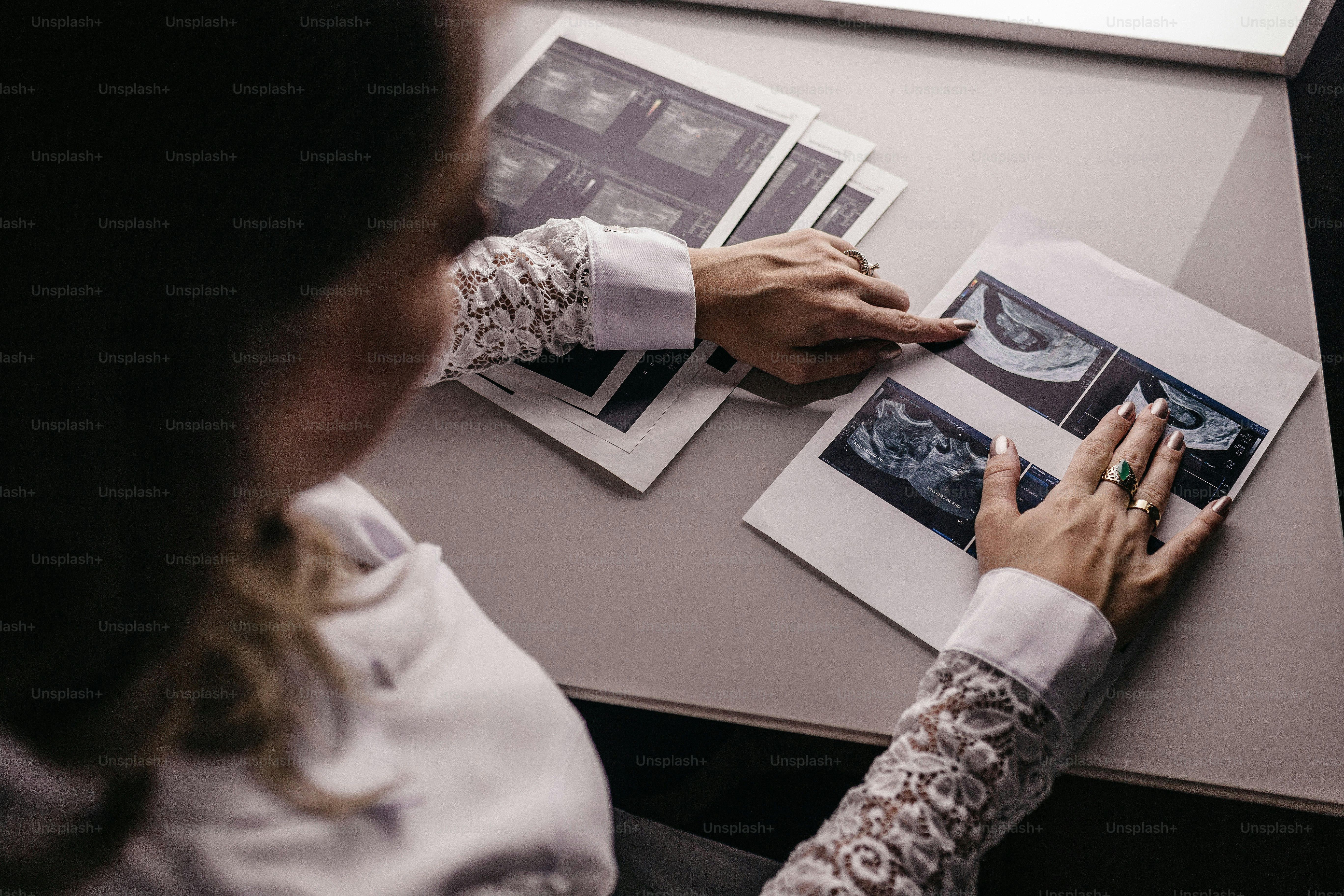 uma mulher sentada em uma mesa trabalhando em um pedaço de papel