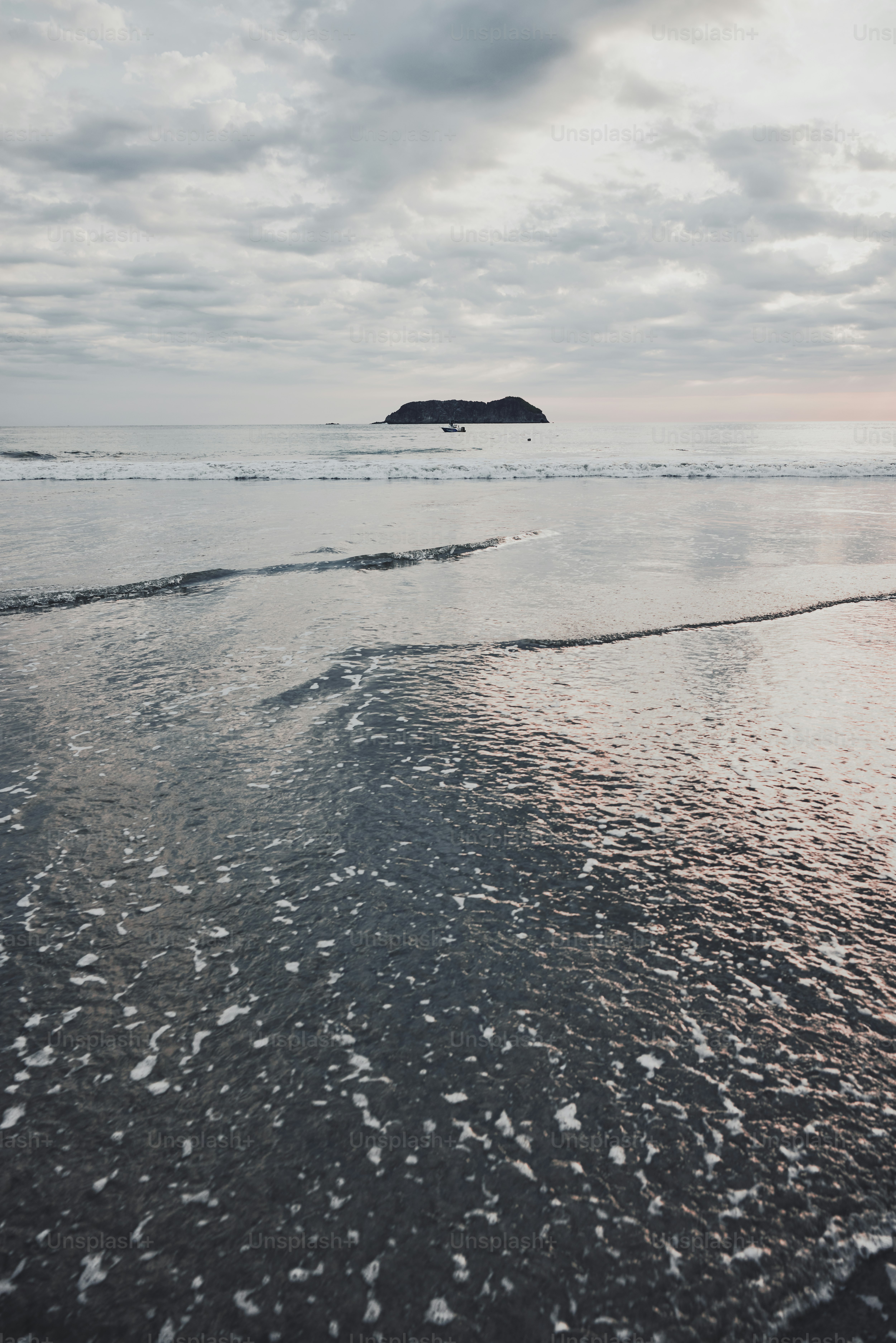 a view of a beach with a small island in the distance