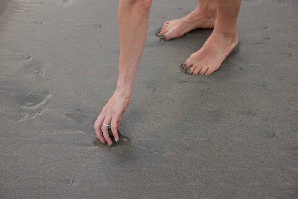 a person standing on a beach with their feet in the sand