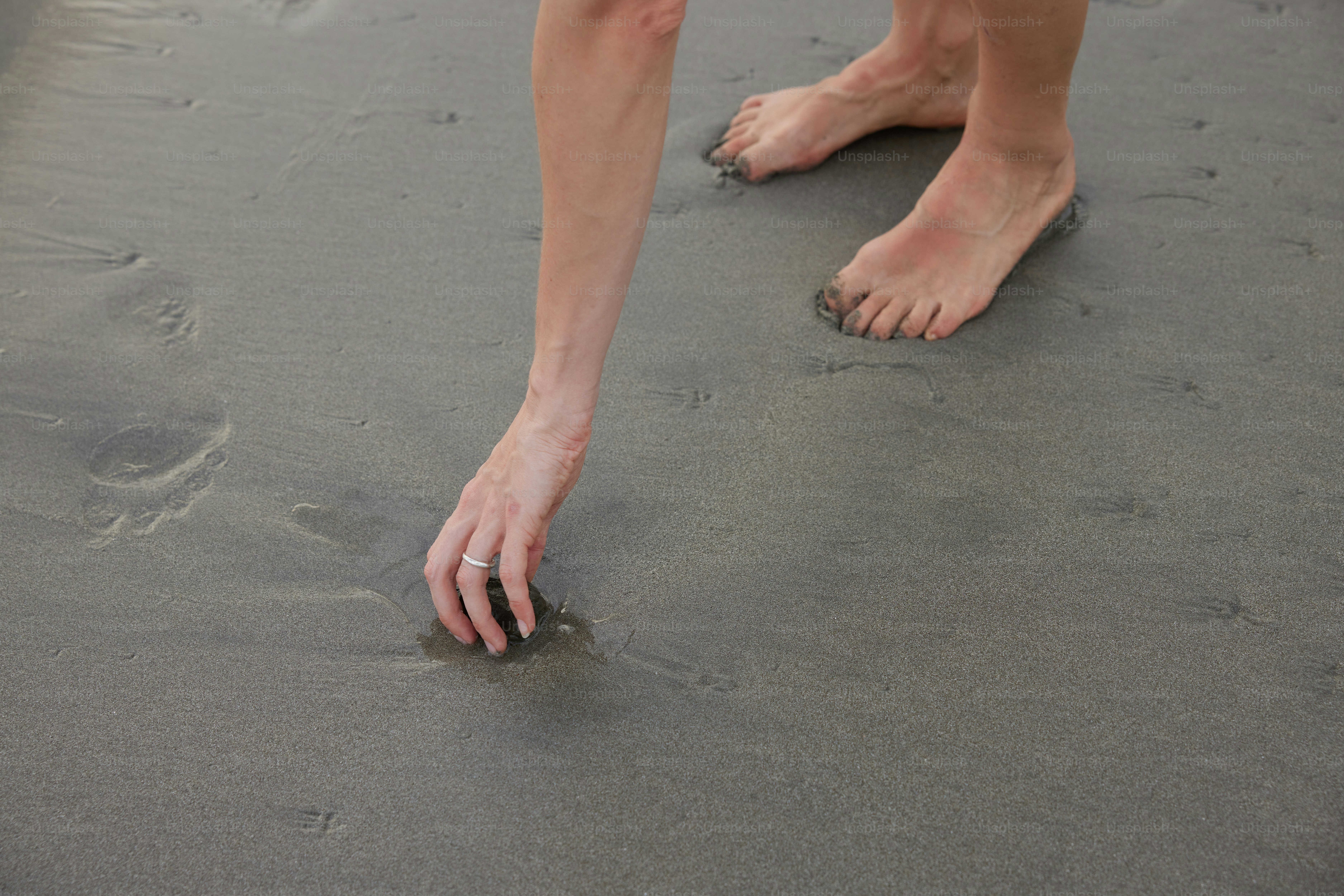 a person standing on a beach with their feet in the sand