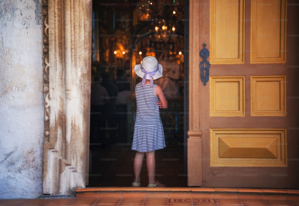 uma garotinha em pé na frente de uma porta
