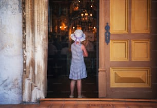 Una niña parada frente a una puerta