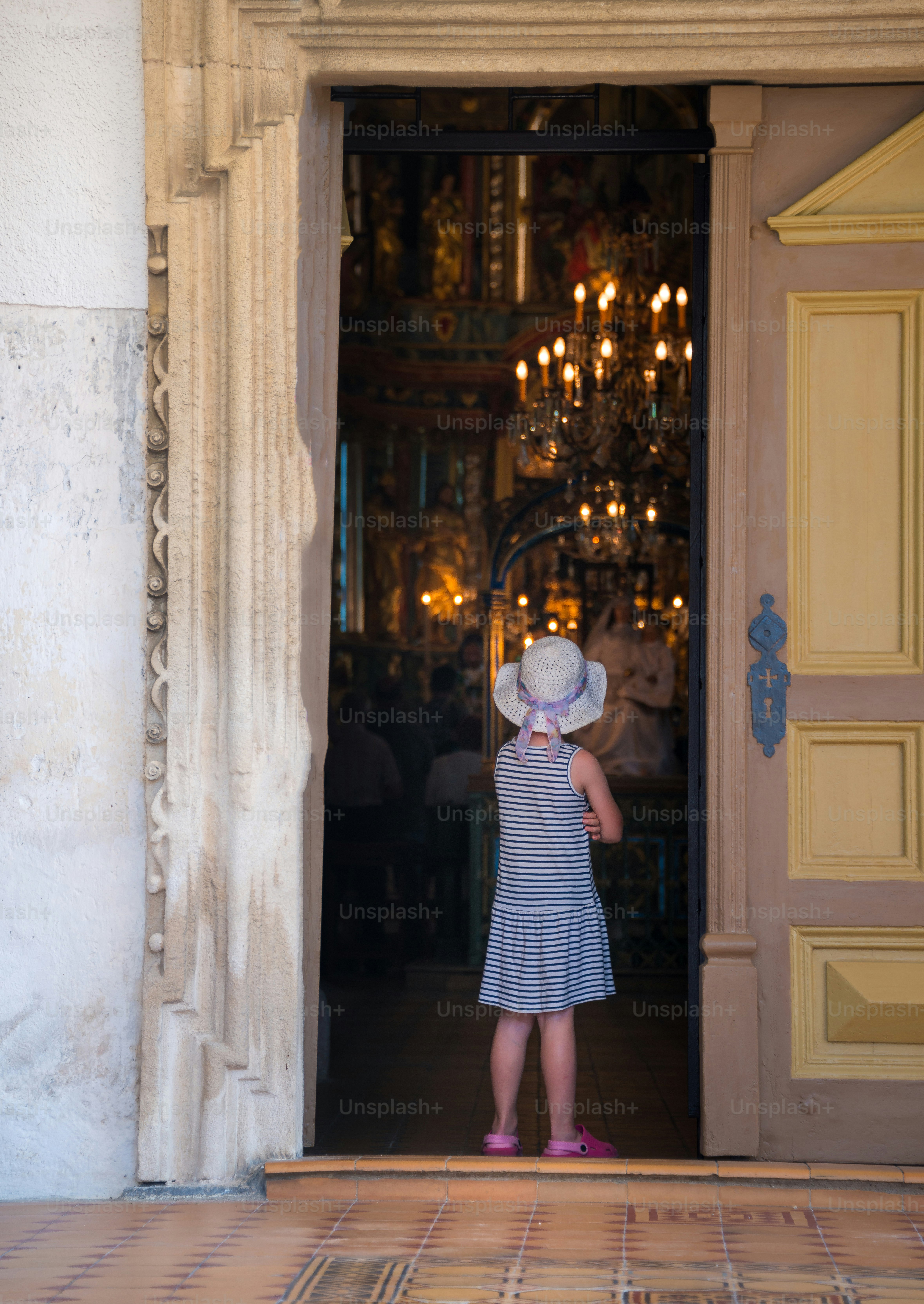 a little girl standing in front of a doorway