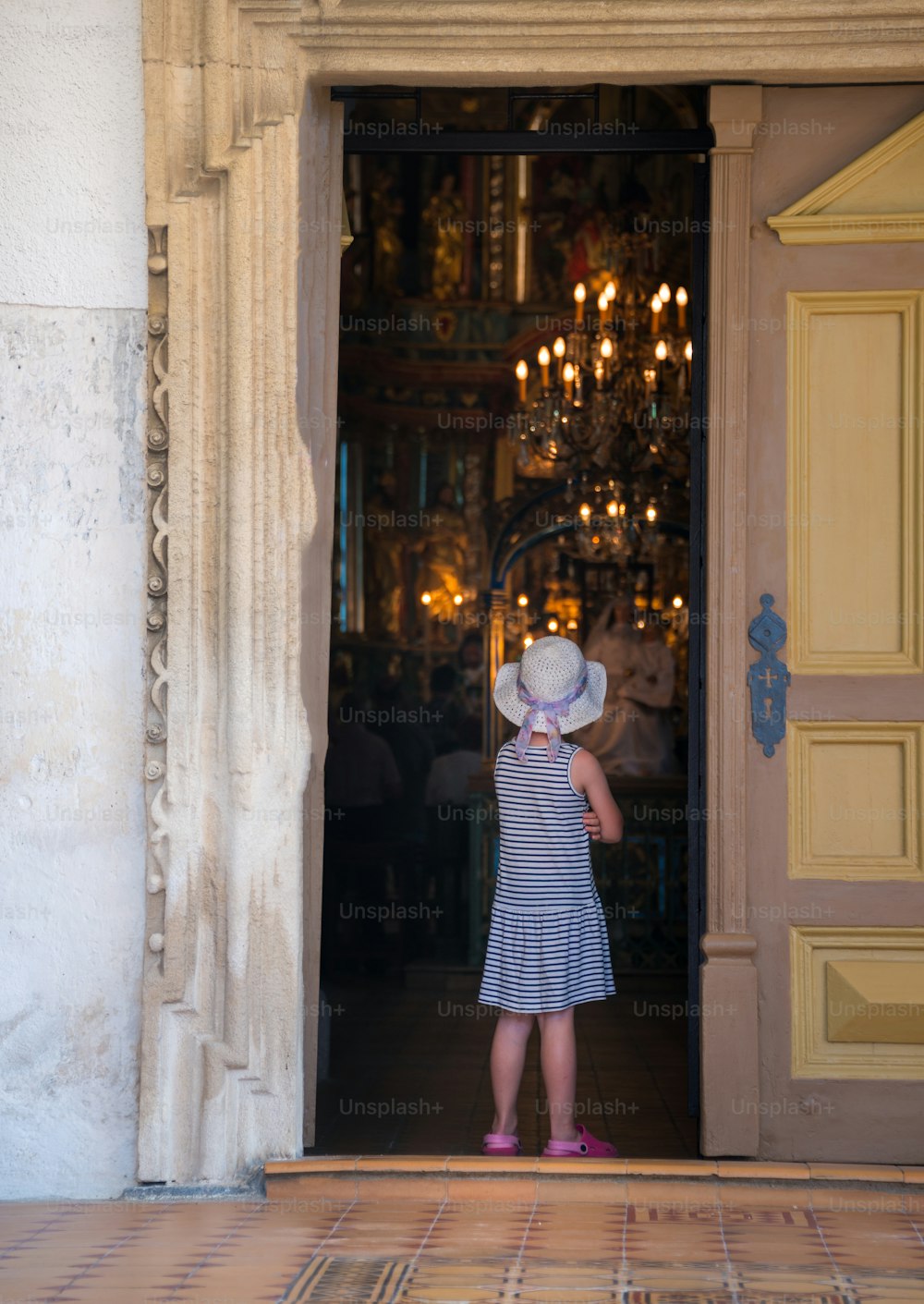 a little girl standing in front of a doorway