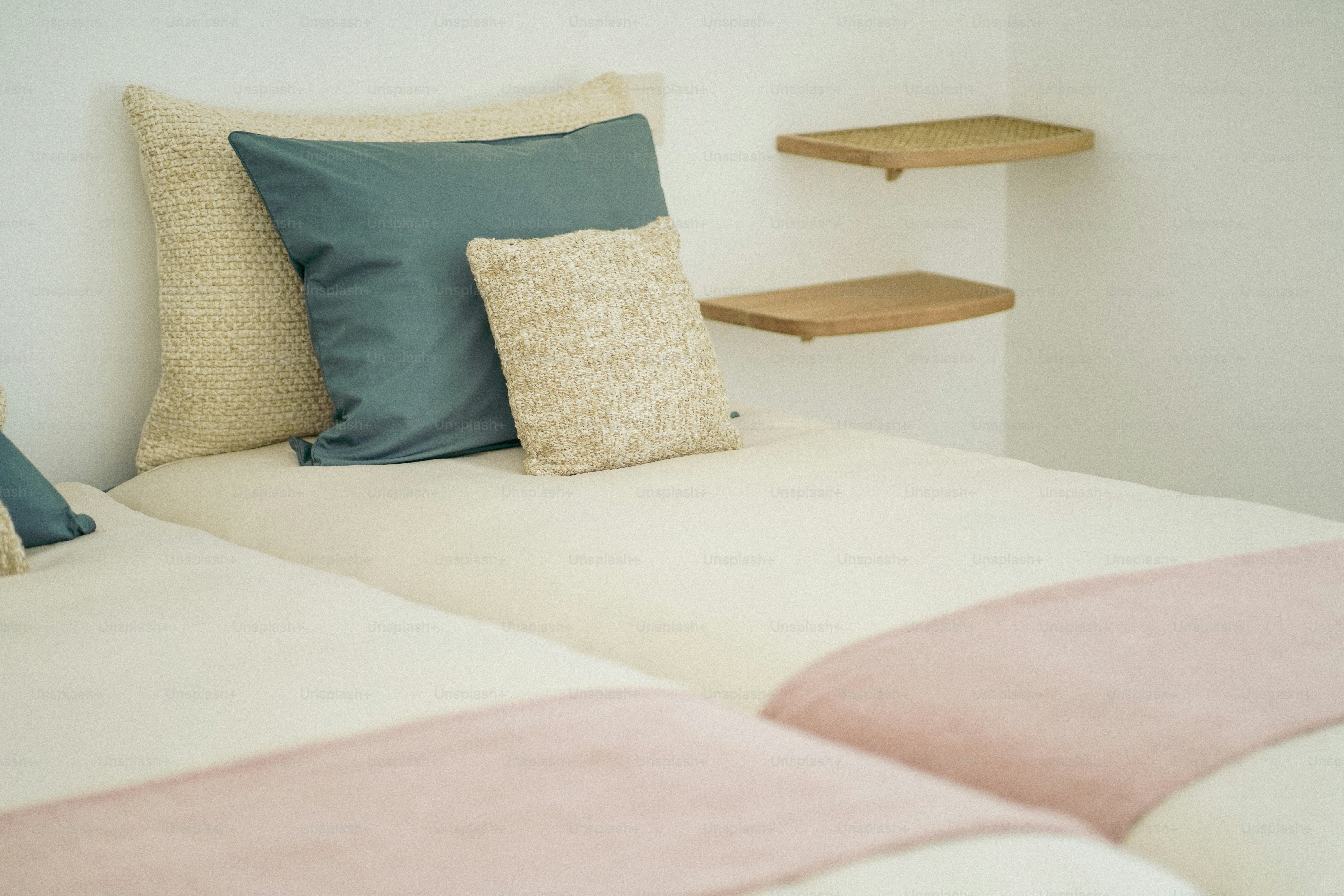 a bed with two pillows and a shelf behind it