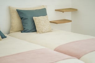 a bed with two pillows and a shelf behind it