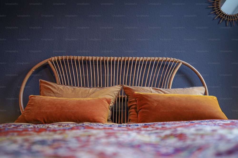 a bed with two orange pillows and a blue wall