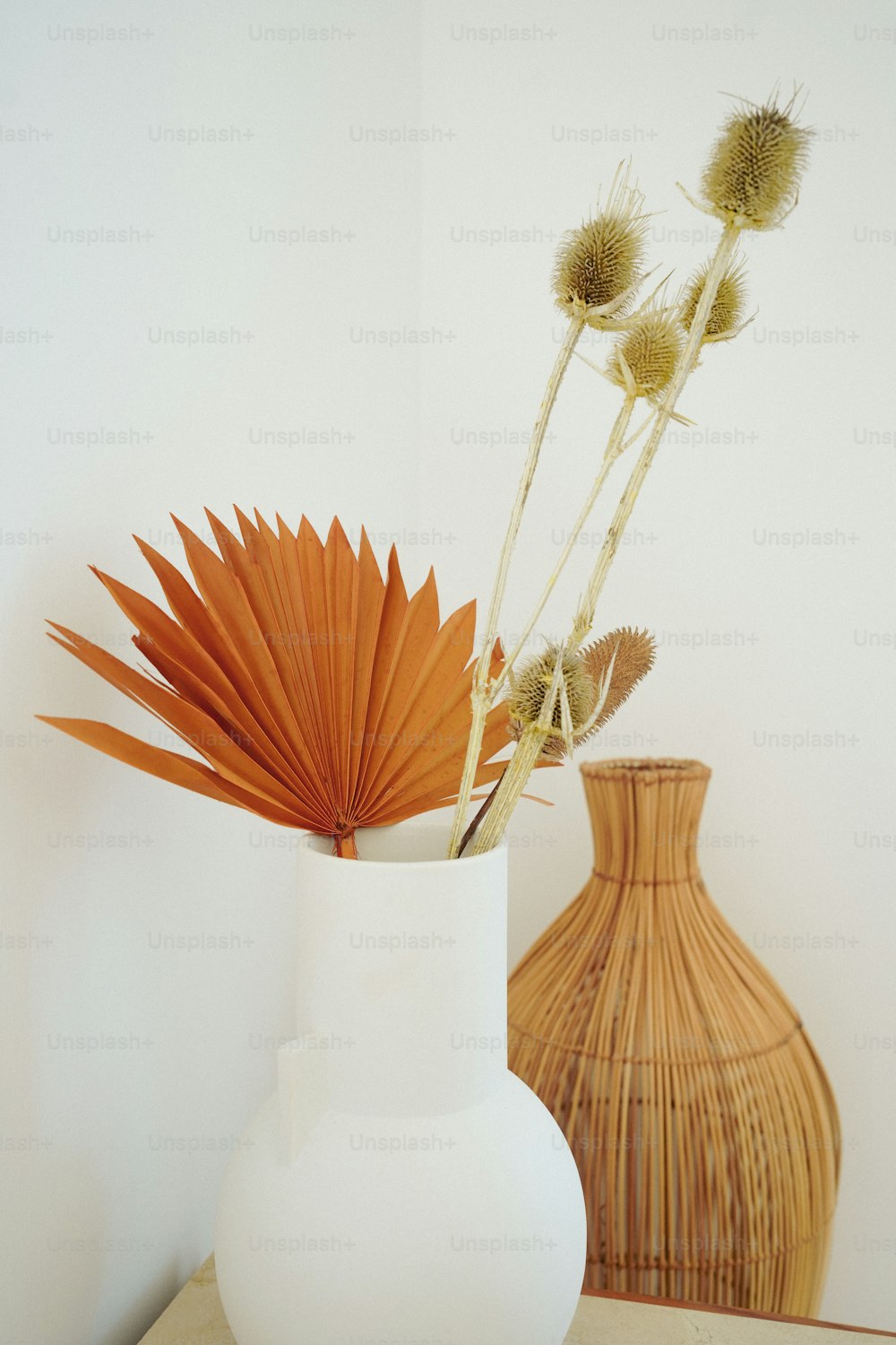 eine weiße Vase gefüllt mit Blumen auf einem Tisch