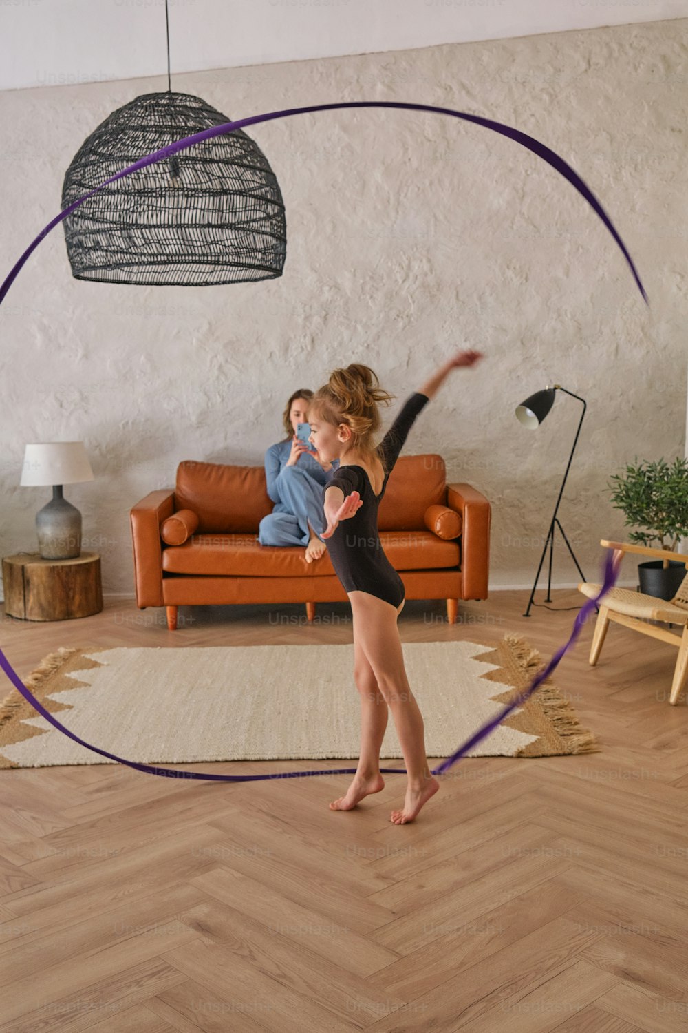 a woman in a black leotard doing a trick in a living room