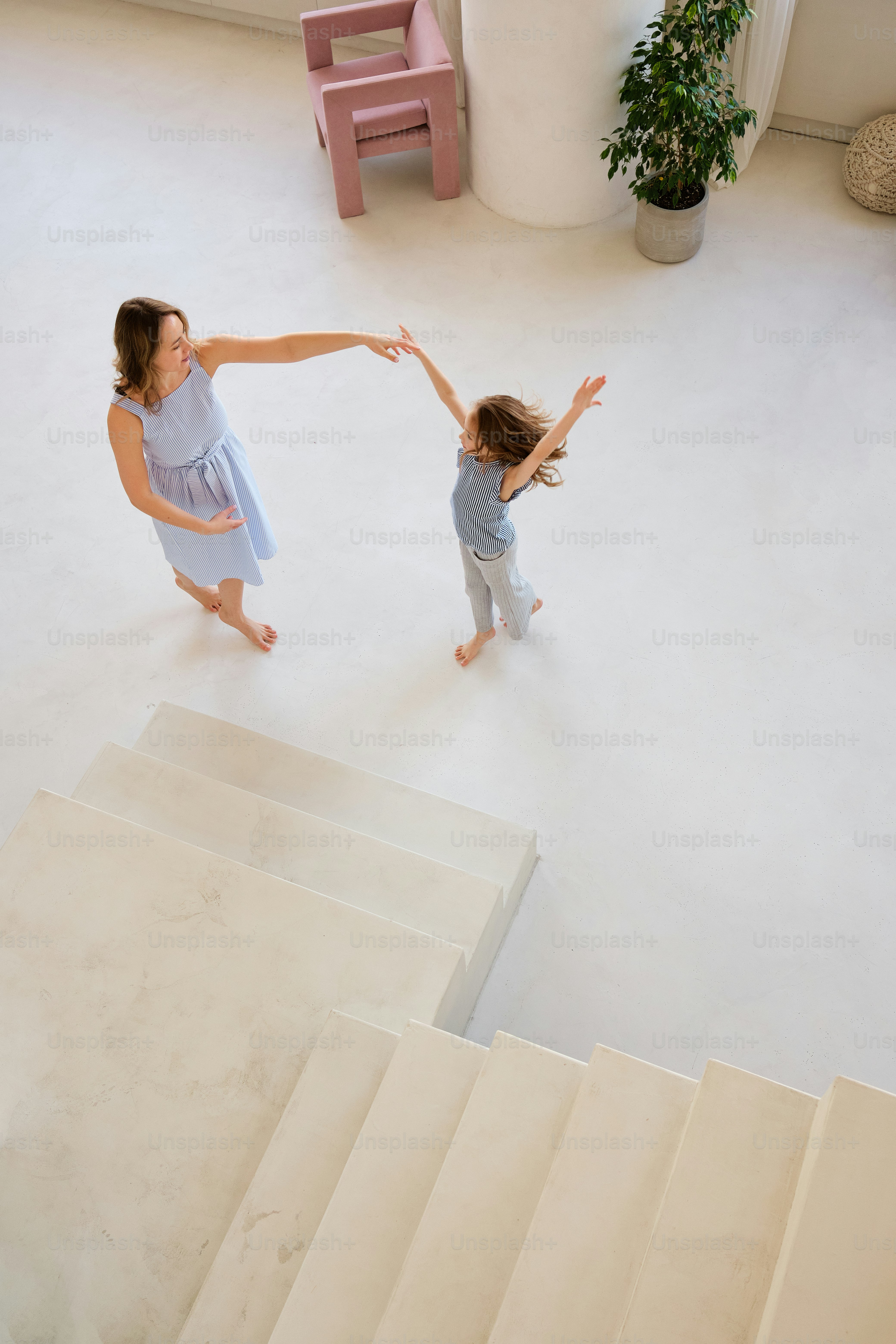 a woman and a little girl are standing on a set of stairs