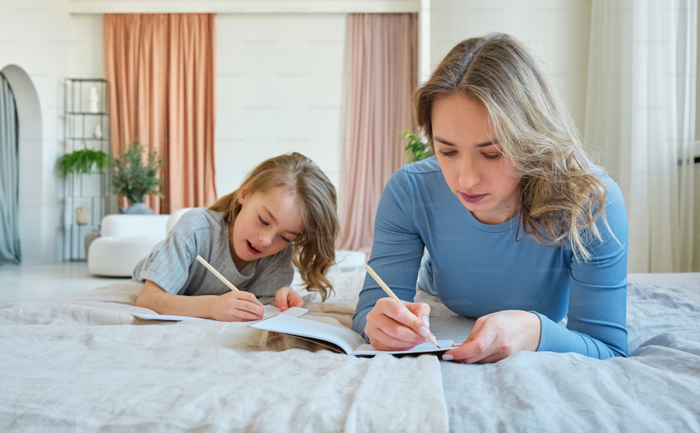 a woman and a little girl laying on a bed