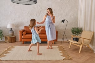 a woman and a little girl standing in a living room