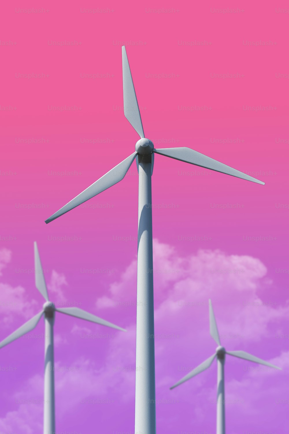 a group of wind turbines against a pink sky