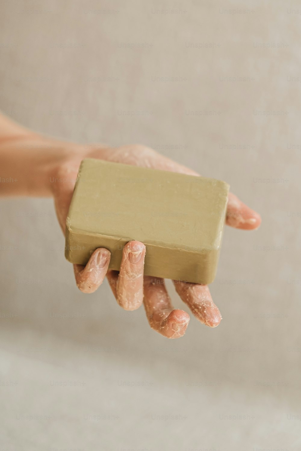 una persona sosteniendo una barra de jabón en la mano