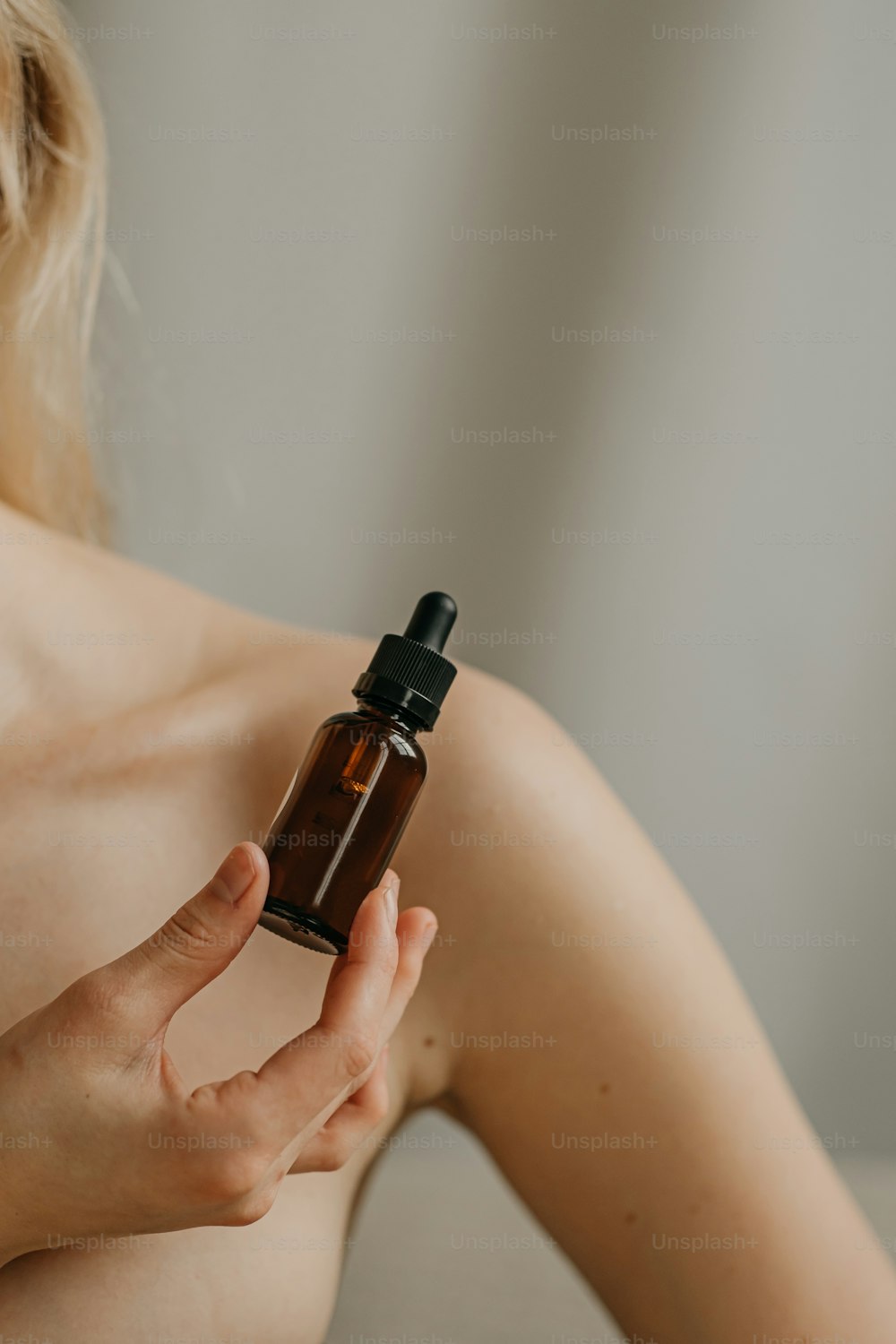 a woman holding a bottle of essential oils