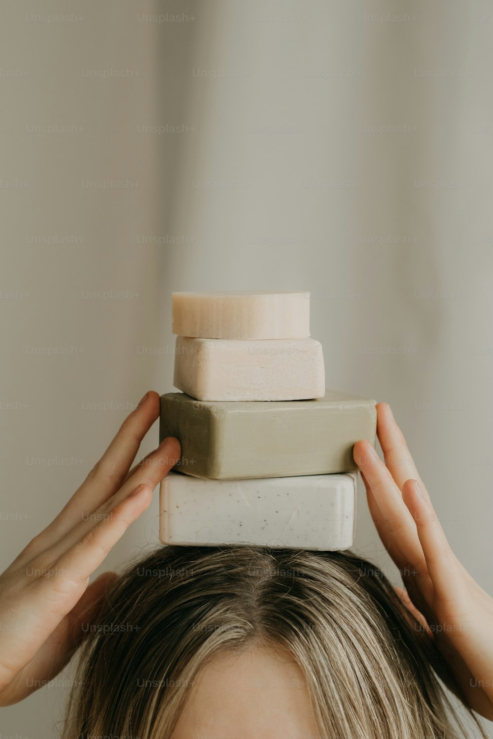 Une femme avec ses mains sur une pile de savons