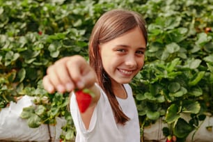 uma menina segurando um pedaço de fruta em sua mão