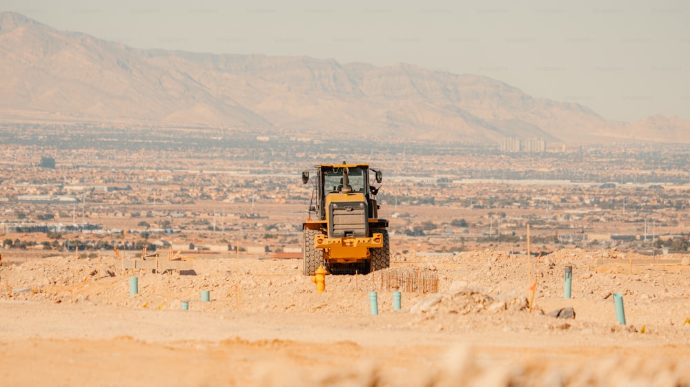 uma grande máquina amarela no meio de um deserto