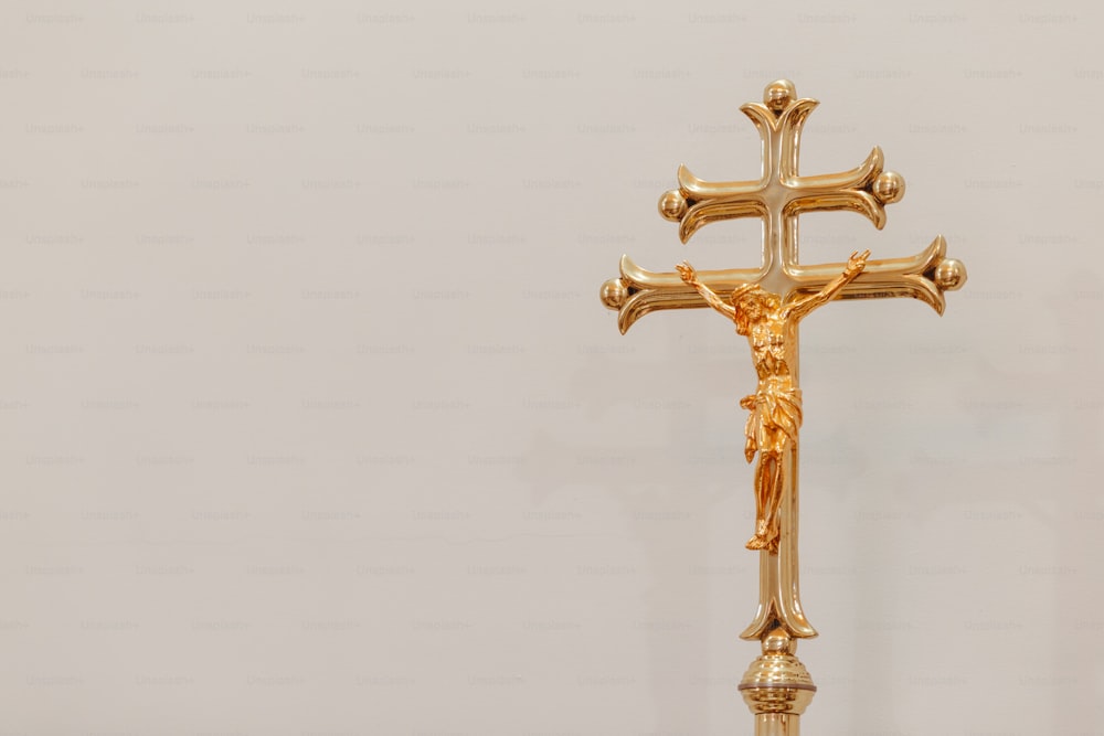 Un crucifijo dorado sobre fondo blanco