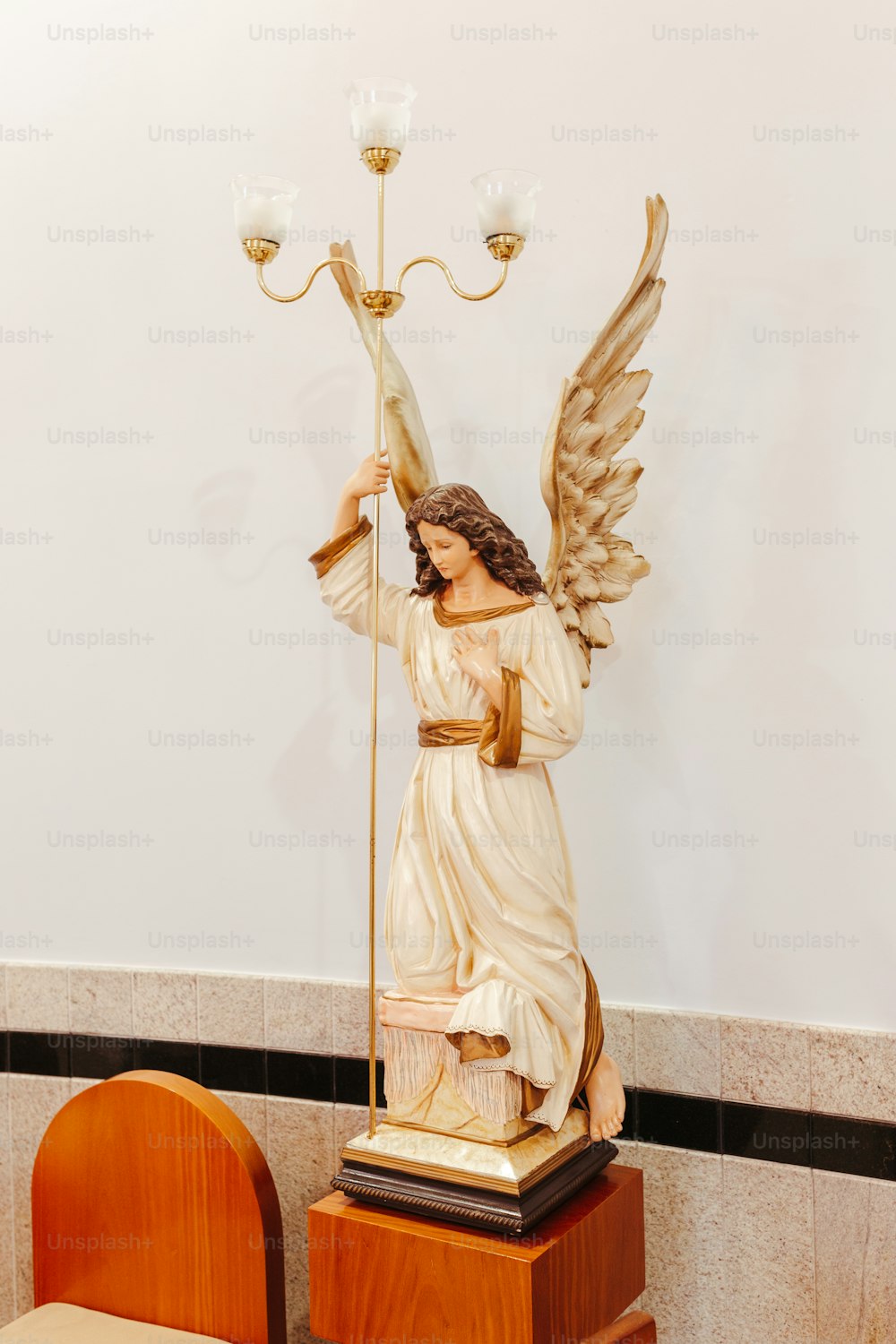 une statue d’un ange tenant une lampe
