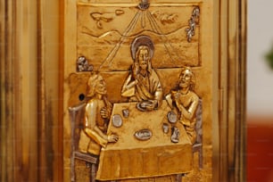テーブルに座っている男性と2人の女性の写真が描かれた金色のドア