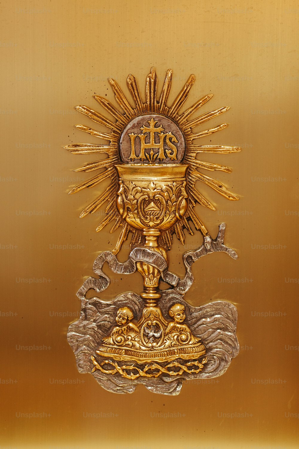uma estátua dourada com uma cruz em cima dela