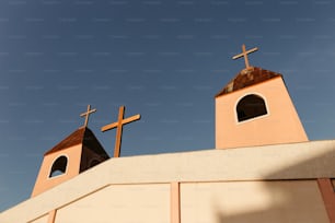 배경에 푸른 하늘이 있는 건물 위에 있는 두 개의 십자가