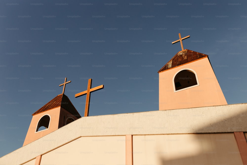 배경에 푸른 하늘이 있는 건물 위에 있는 두 개의 십자가