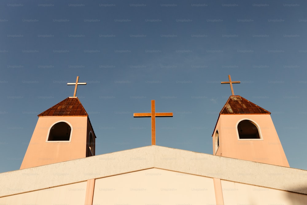 空の背景を持つ建物の上にある2つの十字架