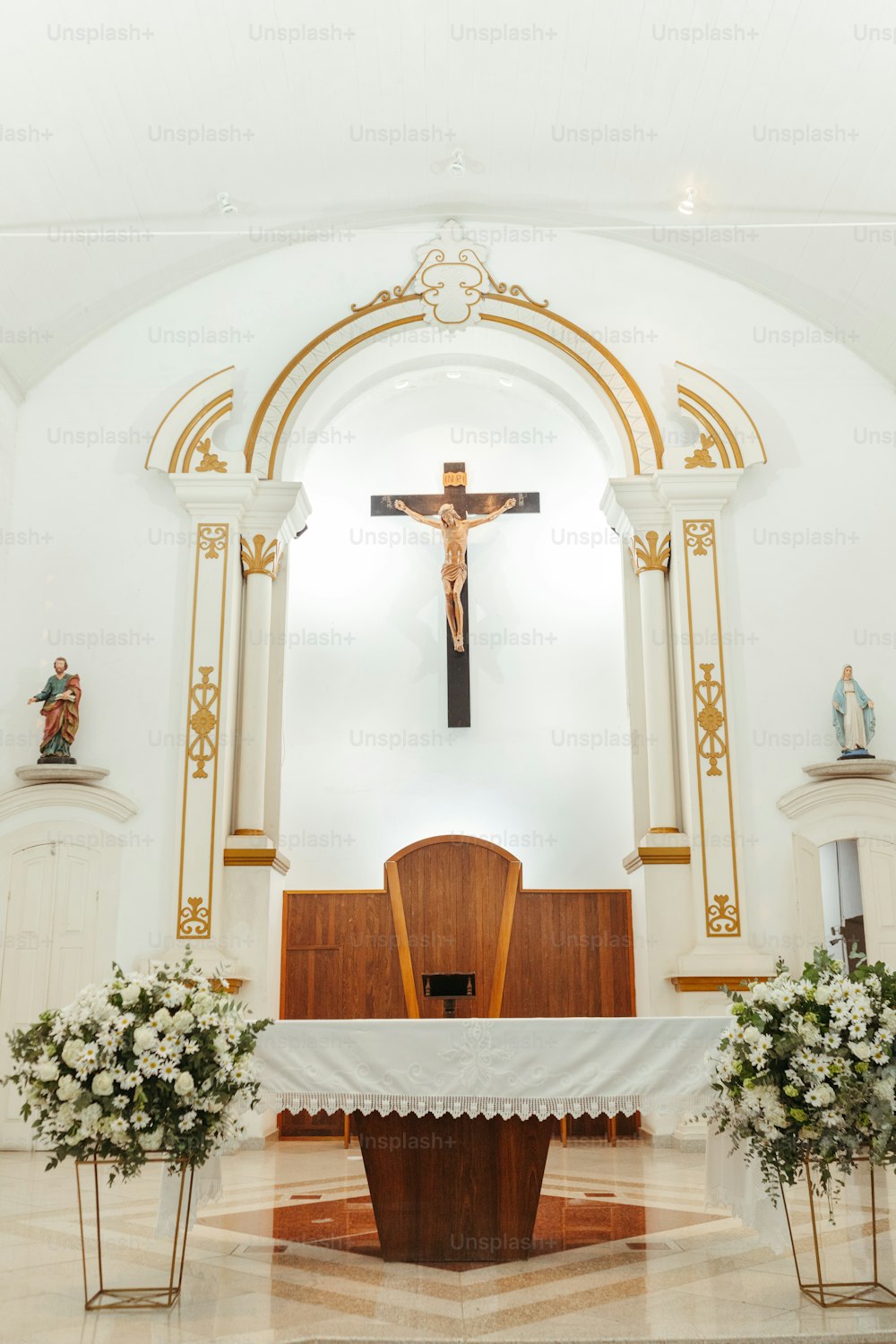 a church with a cross and flowers on the alter