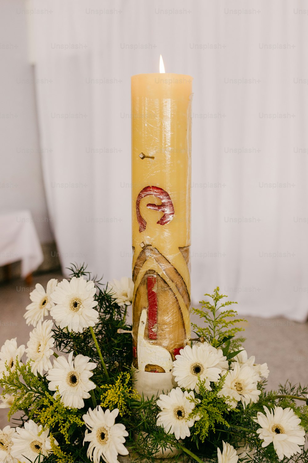 uma vela amarela com uma imagem de uma mulher sobre ela