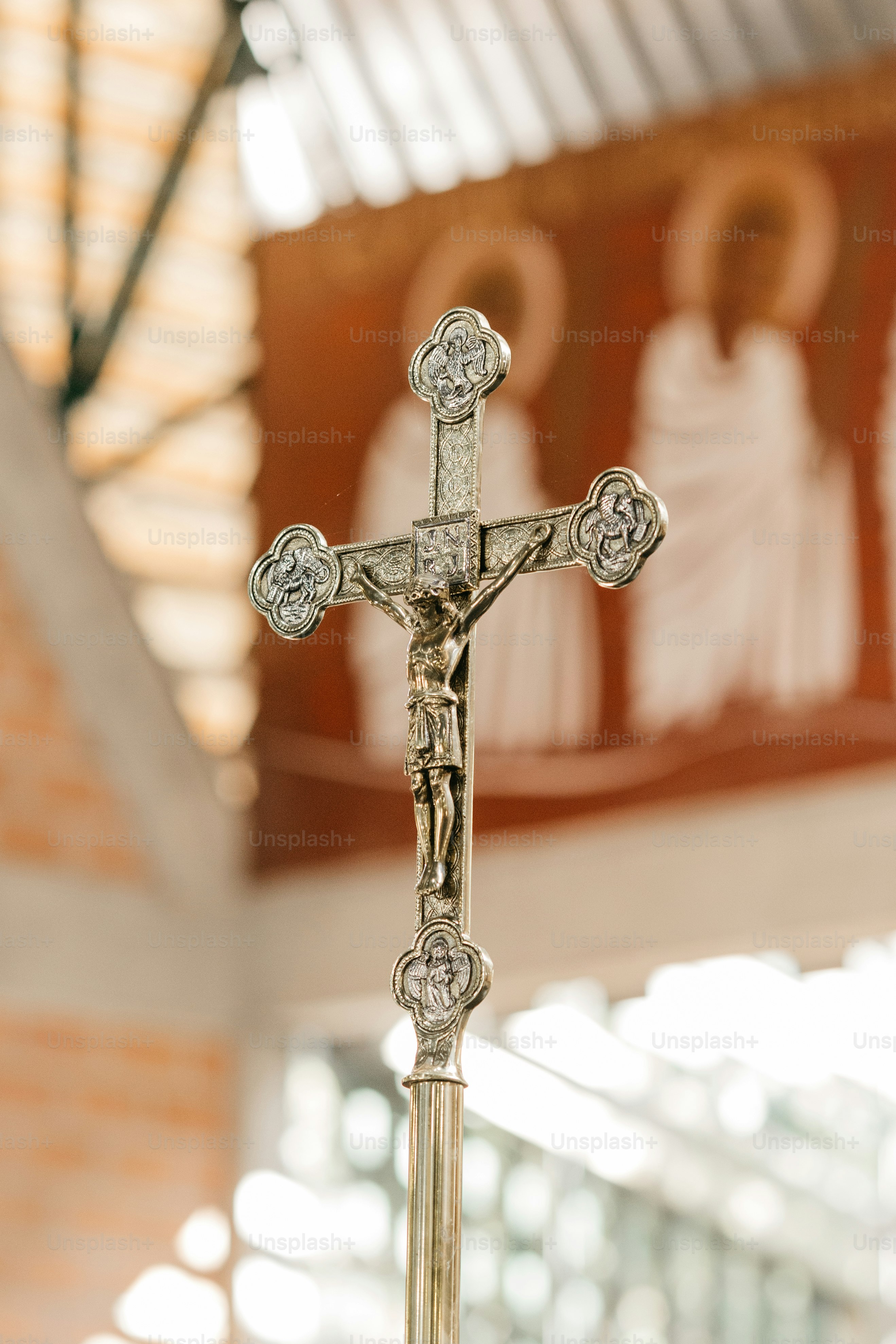a crucifix in front of a wall with paintings on it