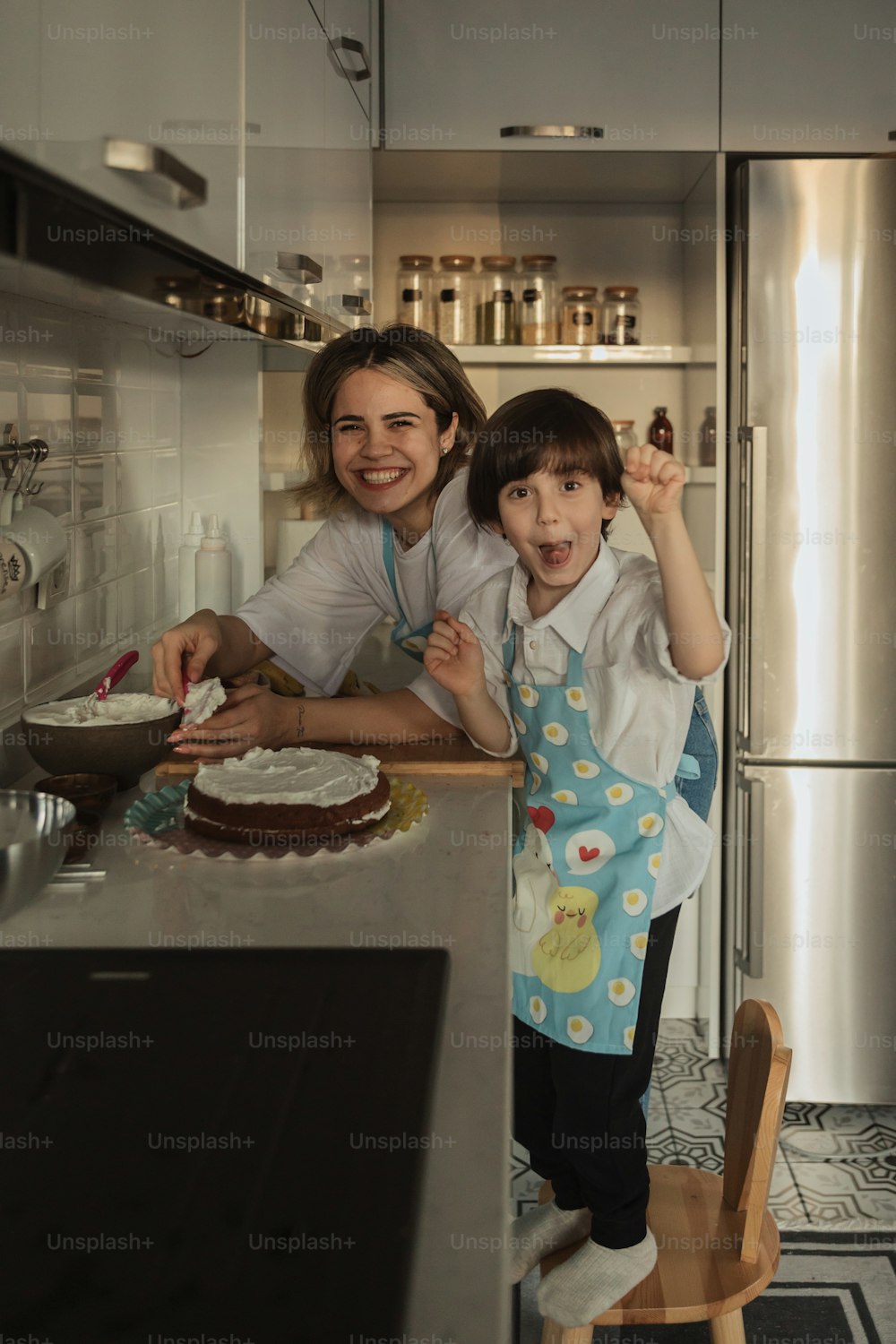 a woman and a child standing in a kitchen