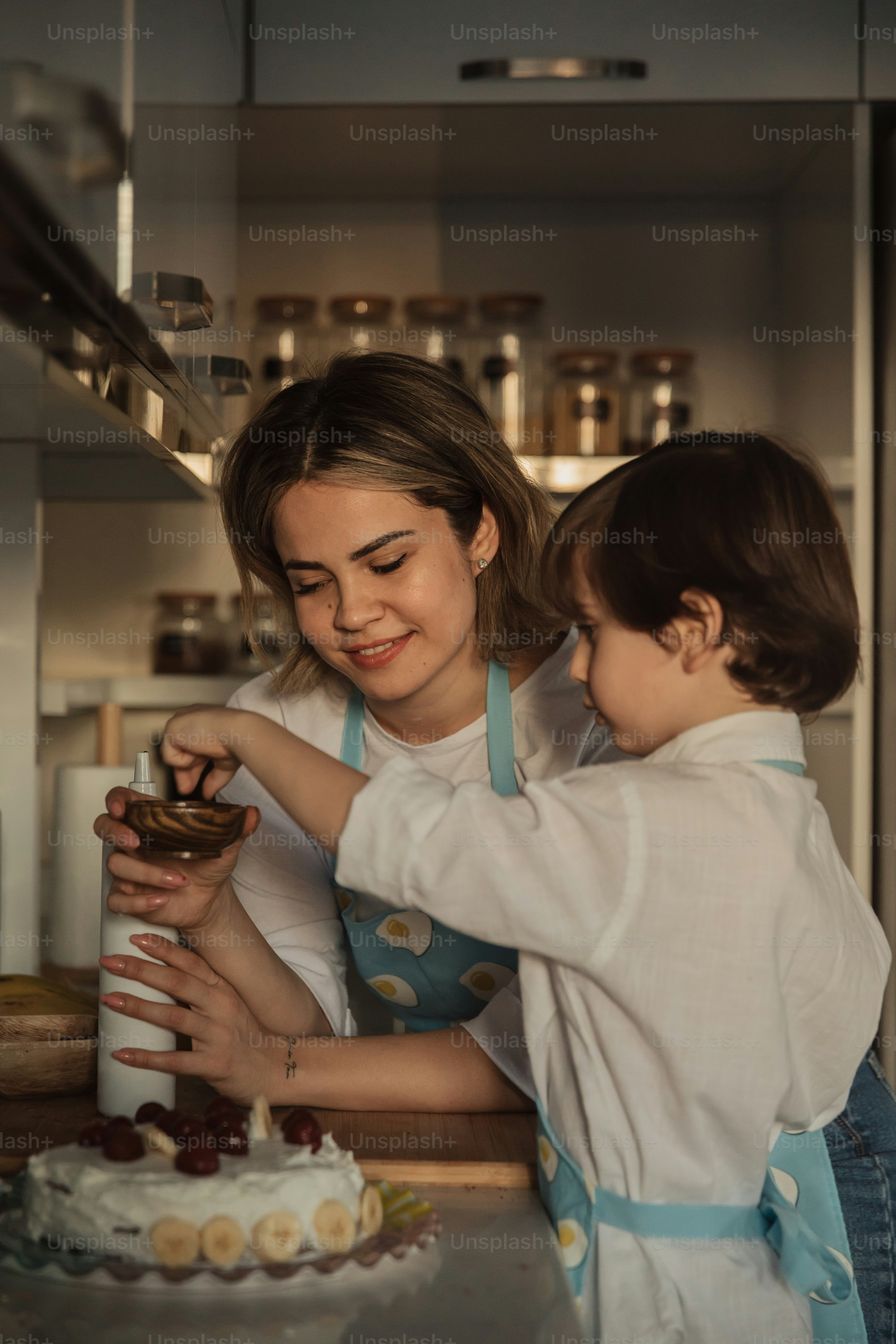 Una mujer y un niño parados frente a un pastel