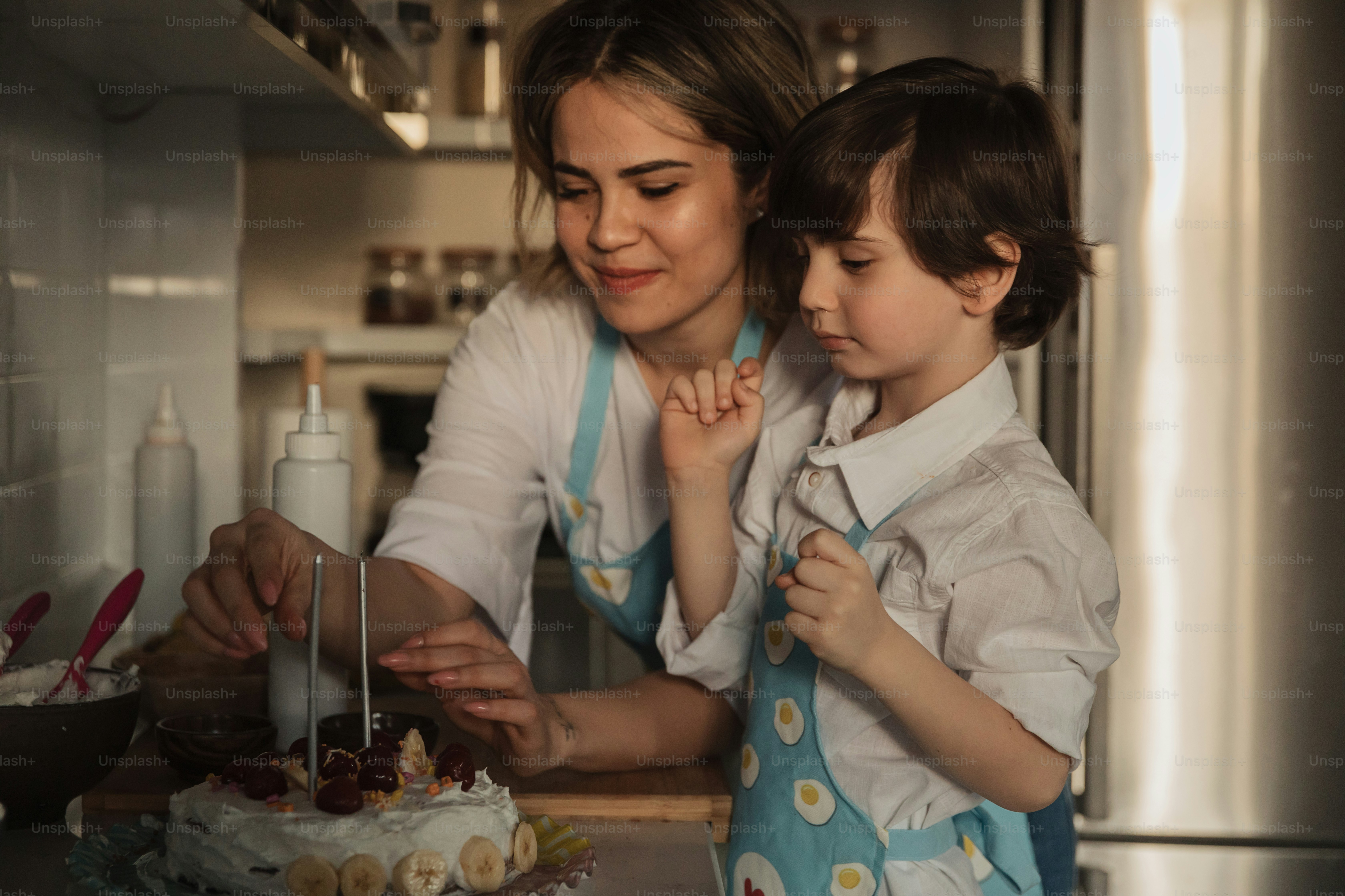 Una mujer y un niño parados frente a un pastel