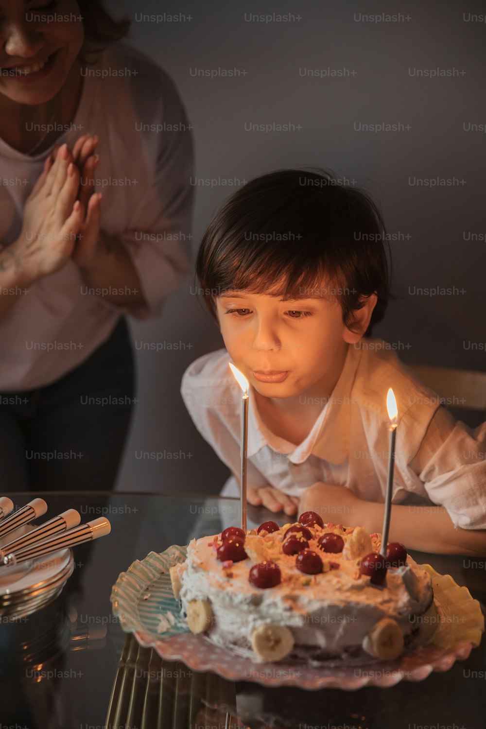 a little boy sitting in front of a cake with candles