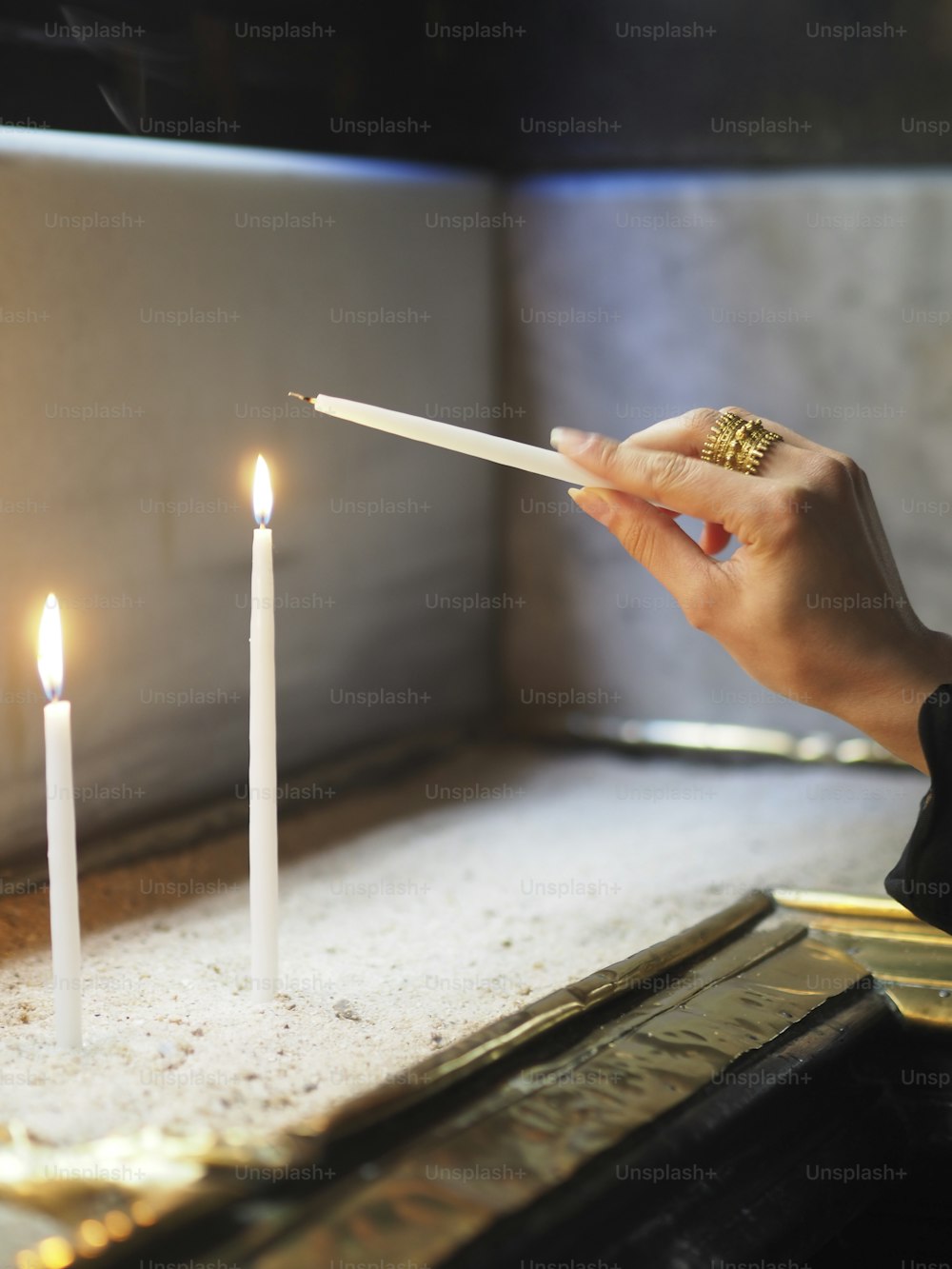 uma pessoa acendendo uma vela em uma mesa
