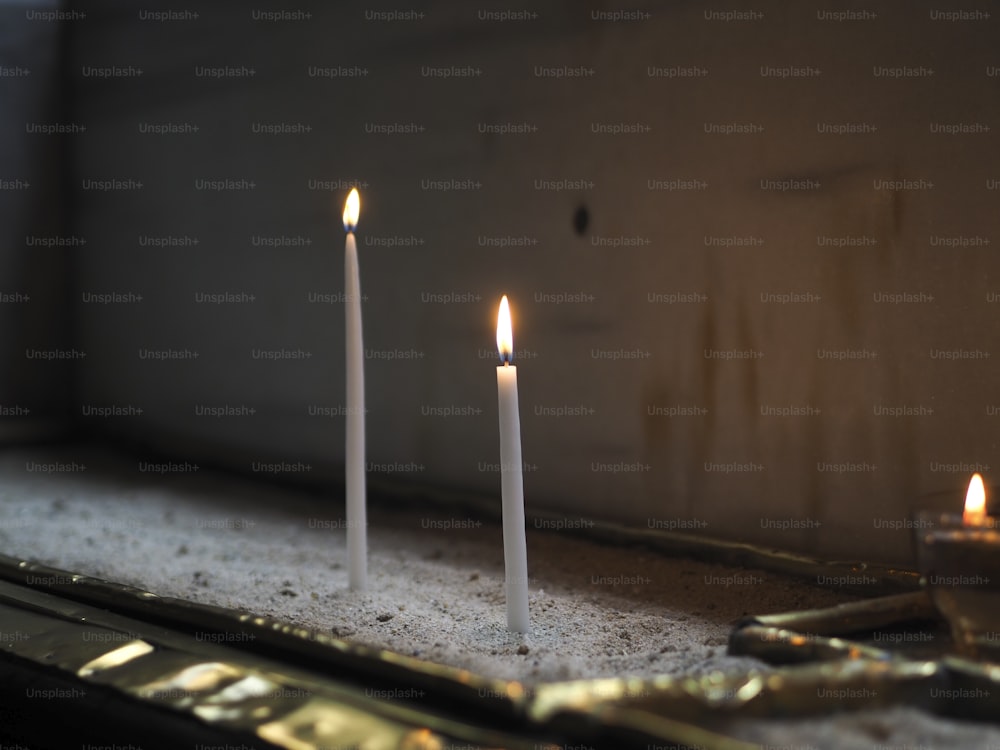 a group of three candles sitting on top of a counter