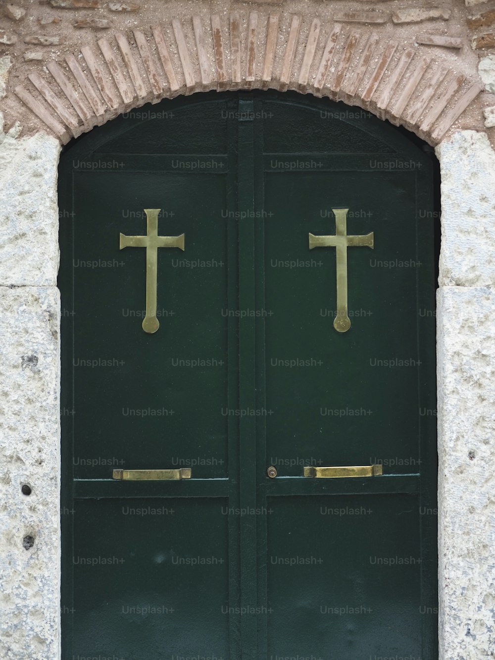 two green doors with gold crosses on them