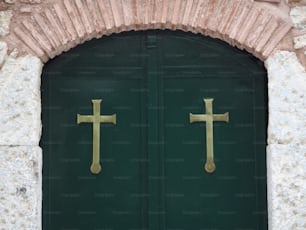eine grüne Tür mit zwei goldenen Kreuzen darauf