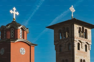 two towers with crosses on top of them against a blue sky