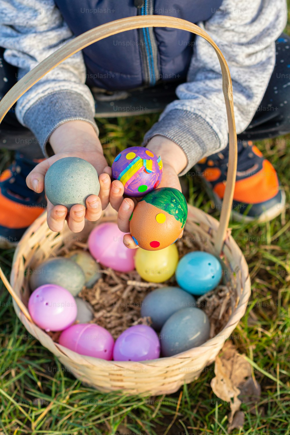 a child holding a basket of eggs in the grass